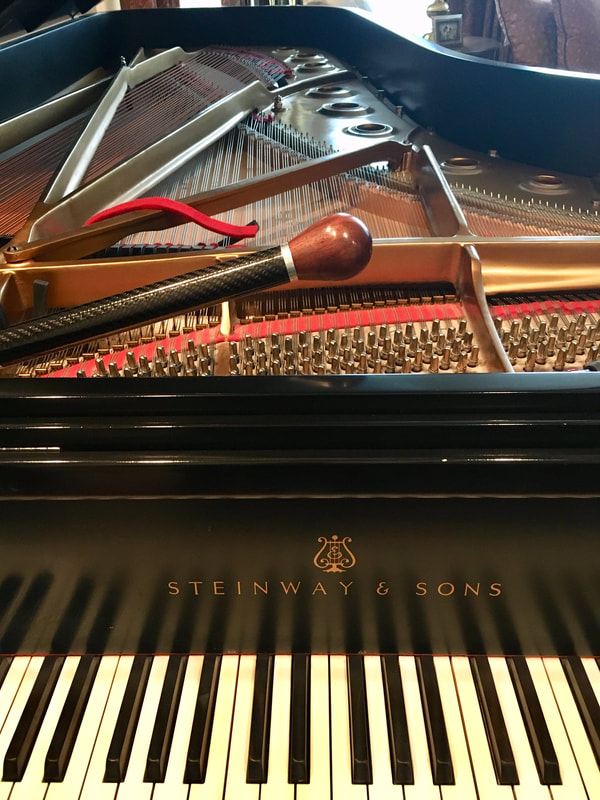 Steinway grand piano with tuning tools resting near the strings